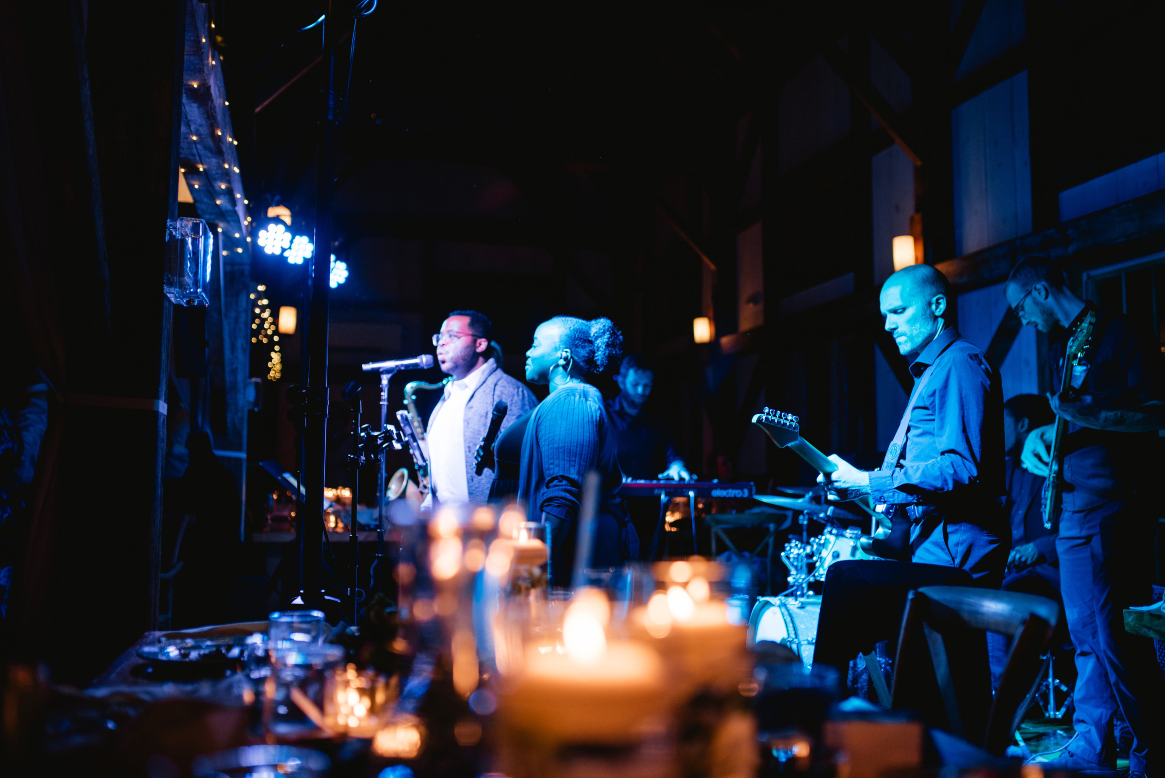 Live band performing at rustic Valley View Farm wedding in Haydenville, MA under blue lighting.