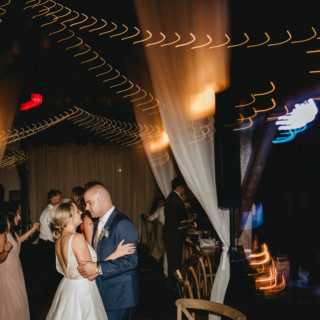 Bride and groom share a romantic first dance under golden lights at Valley View Farm wedding.