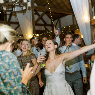 Joyful bride dancing and celebrating with guests at rustic Valley View Farm wedding in Massachusetts.
