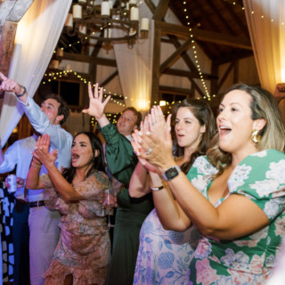 Guests cheer and celebrate during a lively wedding reception at Valley View Farm in Massachusetts.