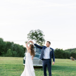 Bride and groom dancing at rustic Valley View Farm wedding in warm evening light.
