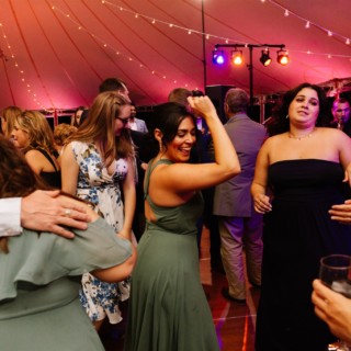 Guests dancing under string lights at a lively Willowdale Estate wedding reception in Topsfield, MA.