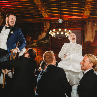 Bride and groom lifted during joyful Hora dance at elegant Boston Public Library wedding.