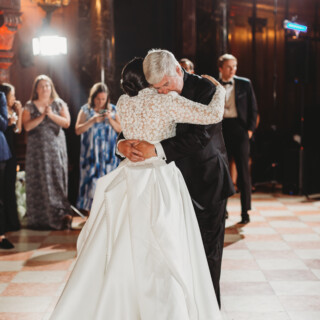 Emotional father-daughter dance at Boston Public Library wedding under warm golden light.