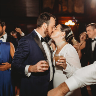 Bride and groom share a romantic kiss at elegant Boston Public Library wedding reception.