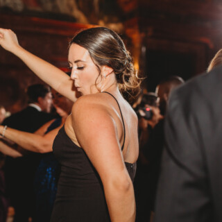 Woman dancing joyfully at elegant Boston Public Library wedding reception.