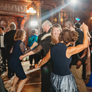 Guests dancing and celebrating at an elegant wedding reception in the Boston Public Library ballroom.