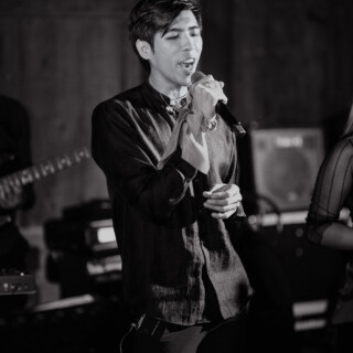 Black and white photo of passionate male singer performing live on stage.