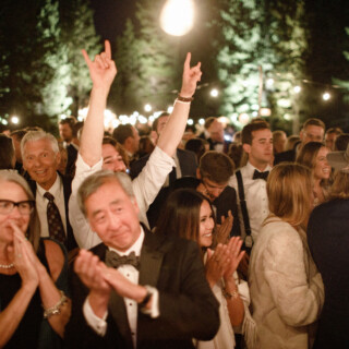 Guests celebrating under string lights at a joyful outdoor wedding in Big Sky, Montana.