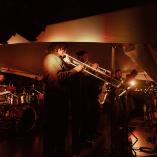 Brass band performing live under warm amber stage lights at a Montana wedding celebration.