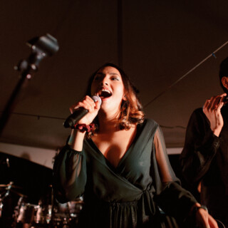 Passionate duo singing live on stage under warm lighting in an intimate concert performance.