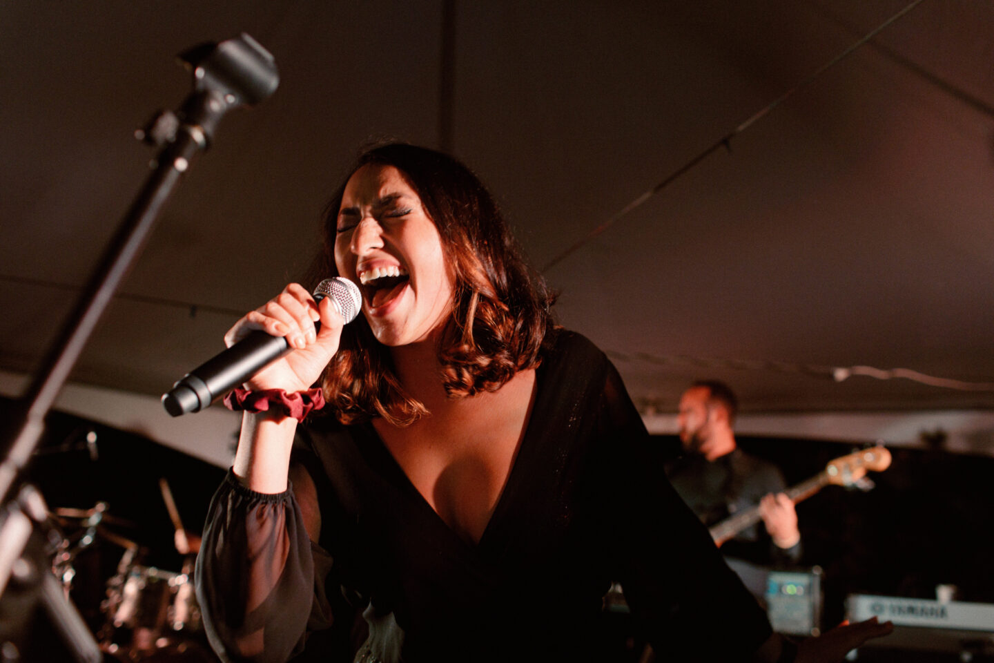 Scenic mountaintop wedding ceremony with white floral arch and panoramic mountain views in Big Sky Montana.