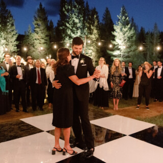 Couple’s first dance under string lights at an elegant Yellowstone Club wedding in Big Sky, Montana.