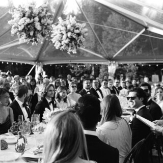 Black-and-white wedding toast under floral canopy at Yellowstone Club in Big Sky, Montana.