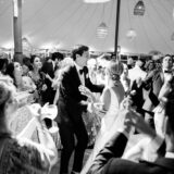 Bride and groom share joyful first dance under lanterns at elegant Nantucket wedding celebration.