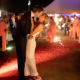 Newlywed couple kissing under sparklers at romantic Nantucket wedding reception night.