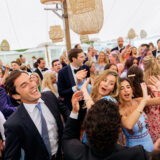 Guests dancing under a bright white tent at a joyful Nantucket wedding celebration