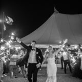 Newlywed couple exits under sparklers at elegant Nantucket wedding night celebration.