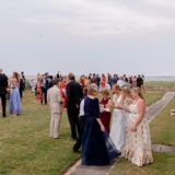Guests enjoy an elegant Nantucket coastal wedding reception with ocean views and live music.