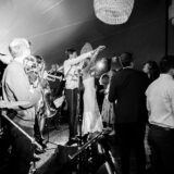 Joyful couple dancing at a lively black-and-white wedding celebration with live band in Nantucket.