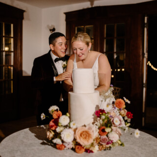 Bride and groom cutting elegant floral wedding cake at French’s Point in Stockton Springs, Maine.