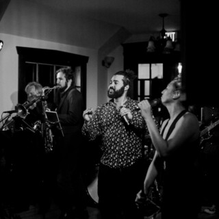 Black and white photo of a soulful live band performance with passionate singers and musicians.