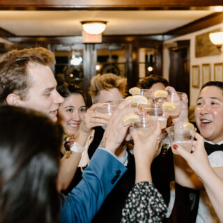 Wedding guests celebrating with a joyful toast at French’s Point reception in Stockton Springs, Maine.