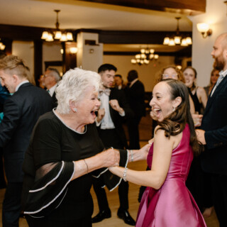 Older and younger women joyfully dancing at elegant French’s Point wedding celebration in Maine.