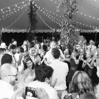 Black and white wedding celebration under twinkling lights at Mount Hope Farm in Bristol, Rhode Island.