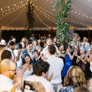 Bride and groom celebrate under glowing tent lights at Mount Hope Farm wedding in Bristol, RI.