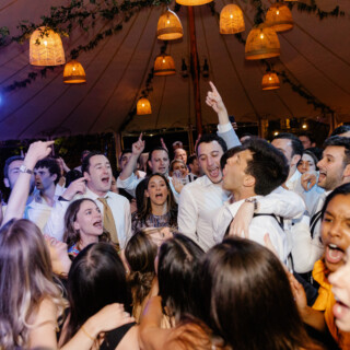 Guests celebrating joyfully under warm lantern lights at Rachel and Brandon’s Willowdale Estate wedding.