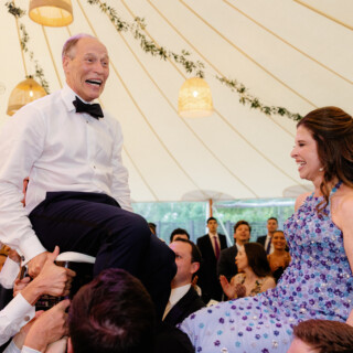 Joyful couple lifted during Hora dance at Willowdale Estate wedding in Topsfield, Massachusetts.