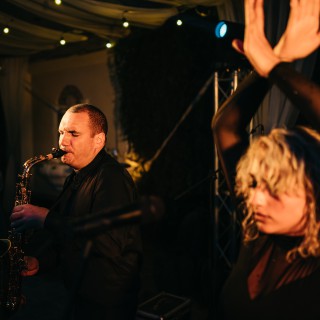 Saxophonist performing under warm lights as guest dances at elegant Antigua Guatemala wedding reception.