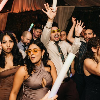 Guests dancing and celebrating under white drapery at a vibrant wedding reception in Antigua Guatemala.