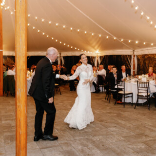 Bride and father share emotional dance under glowing wedding tent lights at Bradley Estate, Massachusetts.