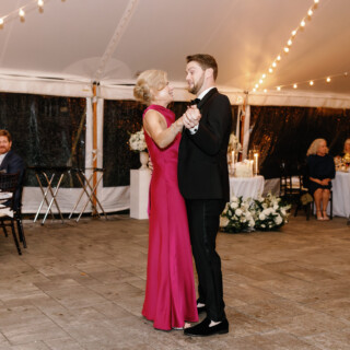 Couple sharing a romantic dance under glowing string lights at an elegant Bradley Estate wedding.