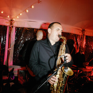 Saxophonist performing live under warm lights at an intimate wedding concert in Canton, Massachusetts.