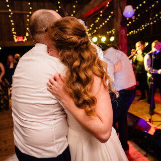 Bride and groom share a romantic first dance at a rustic barn wedding in Maine.