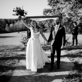 Joyful bride and groom celebrating outdoors at Cunningham Farm wedding in New Gloucester, Maine.