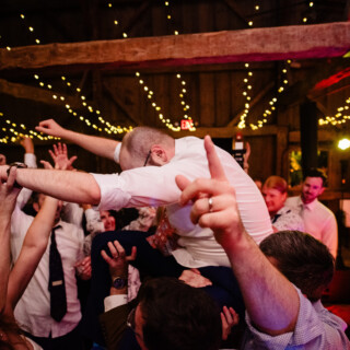 Groom lifted in joy at rustic Cunningham Farm wedding celebration in New Gloucester, Maine.