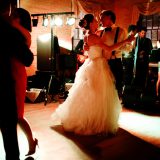Bride and groom share a romantic first dance under warm amber lights at Linden Place wedding.