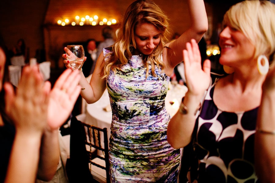 Guests dancing joyfully at a warm, golden-lit Linden Place wedding celebration in Bristol, Rhode Island.