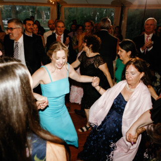Guests dance joyfully in a circle at a Moraine Farm wedding celebration in Beverly, Massachusetts.