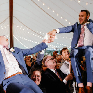 Two grooms lifted during joyful Hora dance at their Moraine Farm wedding celebration in Beverly, MA.