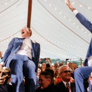 Two grooms lifted during the Hora dance at a joyful Moraine Farm wedding celebration.