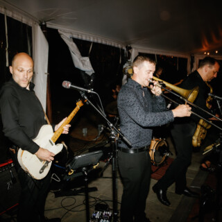 Live band performing under glowing tent at Moraine Farm wedding in Beverly, Massachusetts.