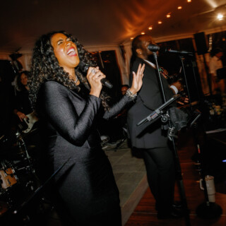 Energetic wedding singers performing live under warm lights at Moraine Farm in Beverly, Massachusetts.