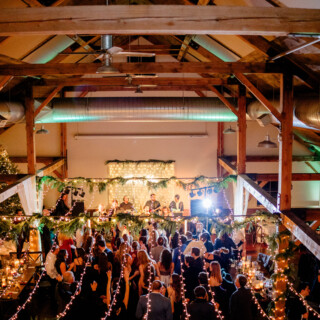 Guests dancing under twinkling lights at rustic barn wedding reception in Chittenden, Vermont.