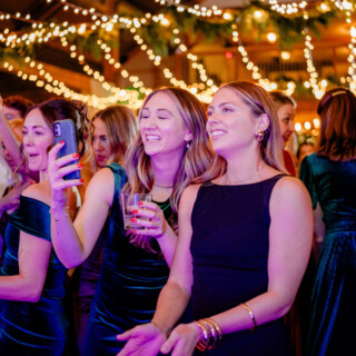 Guests celebrating and dancing under warm fairy lights at a rustic Mountain Top Inn wedding reception.