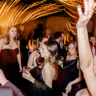 Guests dancing under golden string lights at elegant Mountain Top Inn wedding reception in Vermont.